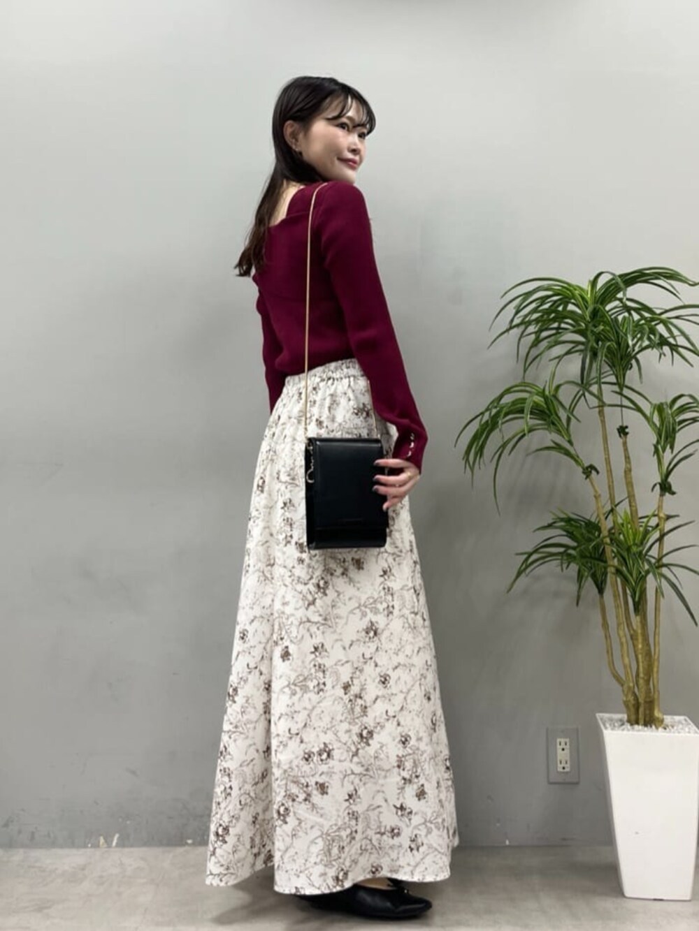 ブラック系のショルダーバッグ、レッド系のニット/セーターを着用したレディースの夏コーディネートの4枚目の写真