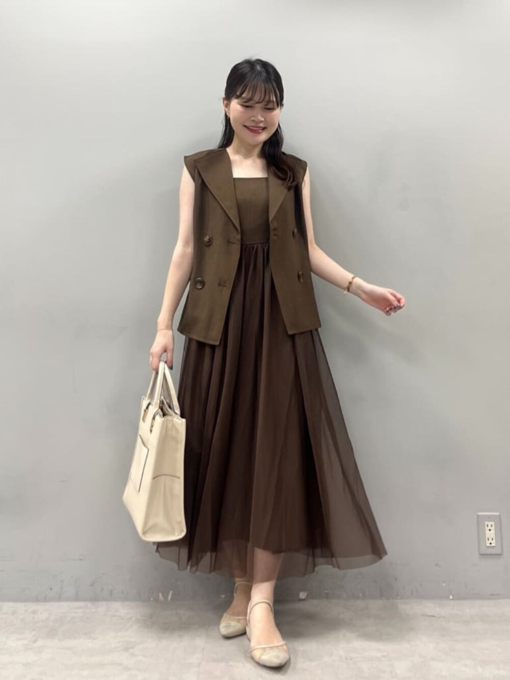 ホワイト系のショルダーバッグ、ブラウン系のワンピースを着用したレディースの夏コーディネートの2枚目の写真