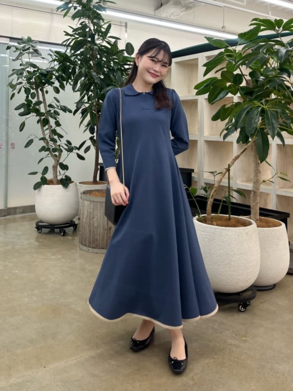 ブラック系のショルダーバッグ、ブルー系のワンピース、ブラック系のワンピースを着用したレディースの夏コーディネートの2枚目の写真