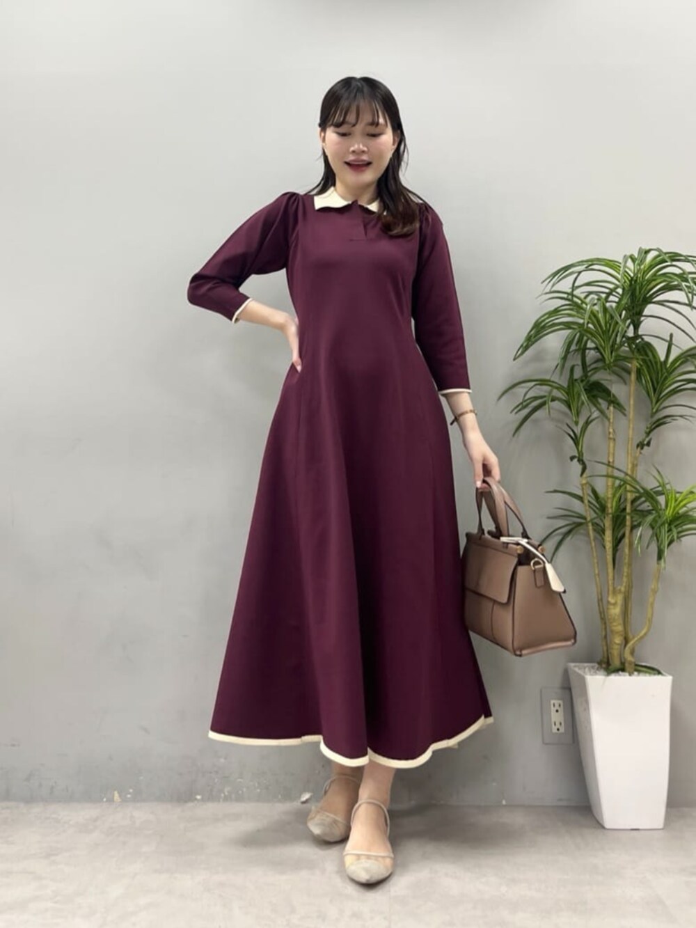 ブラウン系のショルダーバッグ、レッド系のワンピースを着用したレディースの夏コーディネートの2枚目の写真