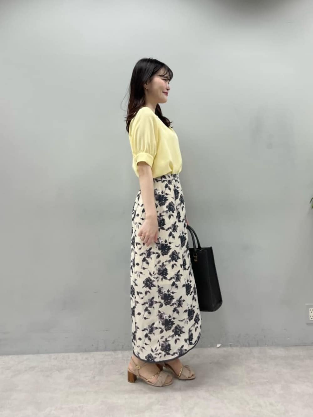 ブラック系のショルダーバッグ、イエロー系のシャツ/ブラウス、その他のスカートを着用したレディースの夏コーディネートの2枚目の写真