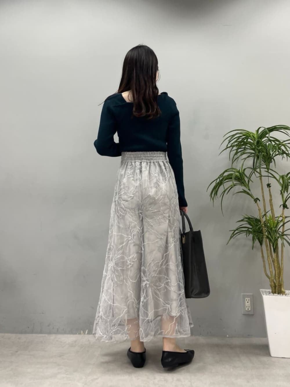 ブラック系のショルダーバッグ、グリーン系のニット/セーターを着用したレディースの夏コーディネートの5枚目の写真