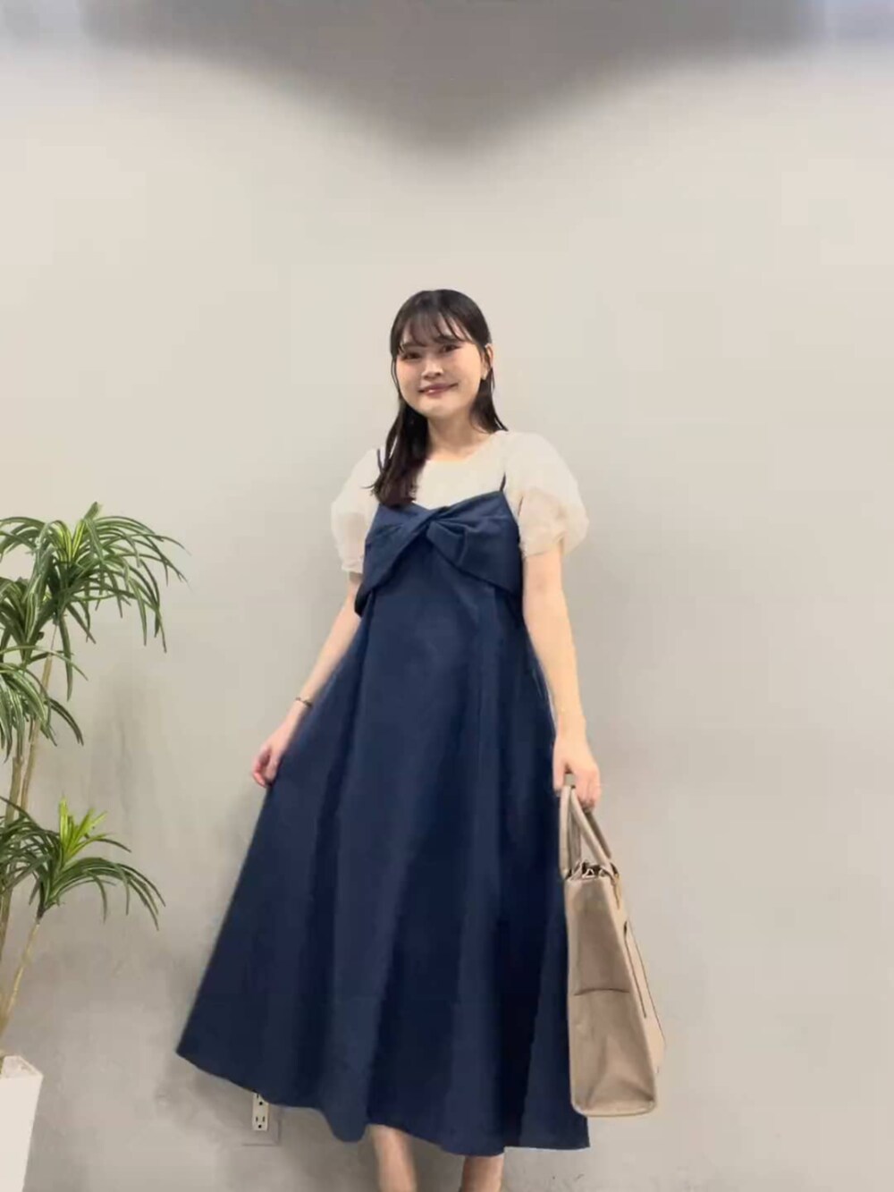 ブルー系のワンピース、ブラック系のショルダーバッグ、ホワイト系のシャツ/ブラウスを着用したレディースの夏コーディネートの2枚目の写真