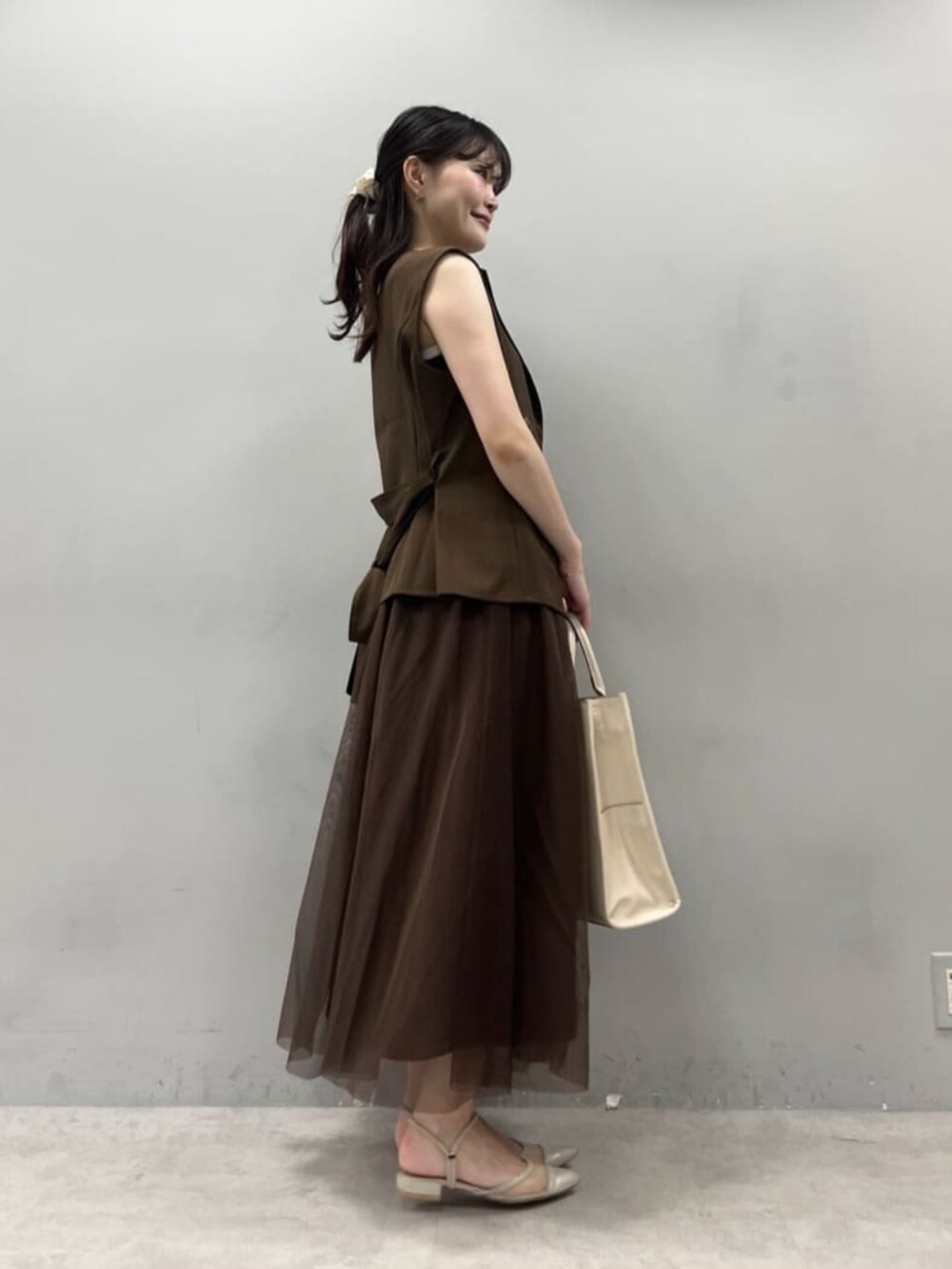 ホワイト系のショルダーバッグ、ブラウン系のワンピースを着用したレディースの夏コーディネートの3枚目の写真