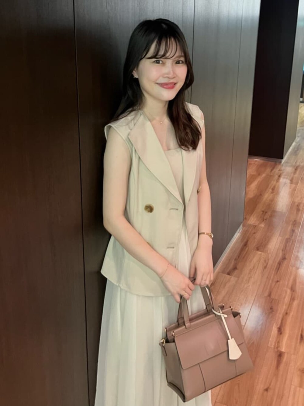 ホワイト系のワンピース、ブラウン系のショルダーバッグを着用したレディースの夏コーディネートの2枚目の写真