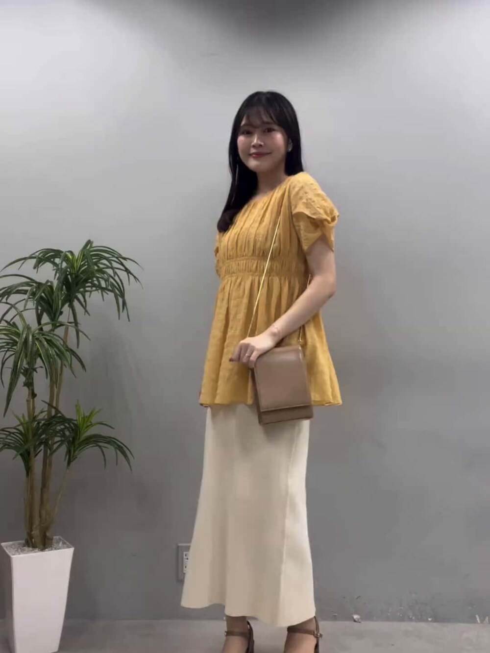 ブラウン系のその他シューズ、ベージュ系のショルダーバッグ、ホワイト系のスカートを着用したレディースの夏コーディネートの2枚目の写真