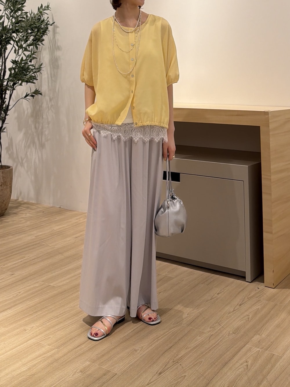 イエロー系のシャツ/ブラウス、シルバー系のサンダル、グレー系のその他パンツを着用したレディースの夏コーディネートの2枚目の写真