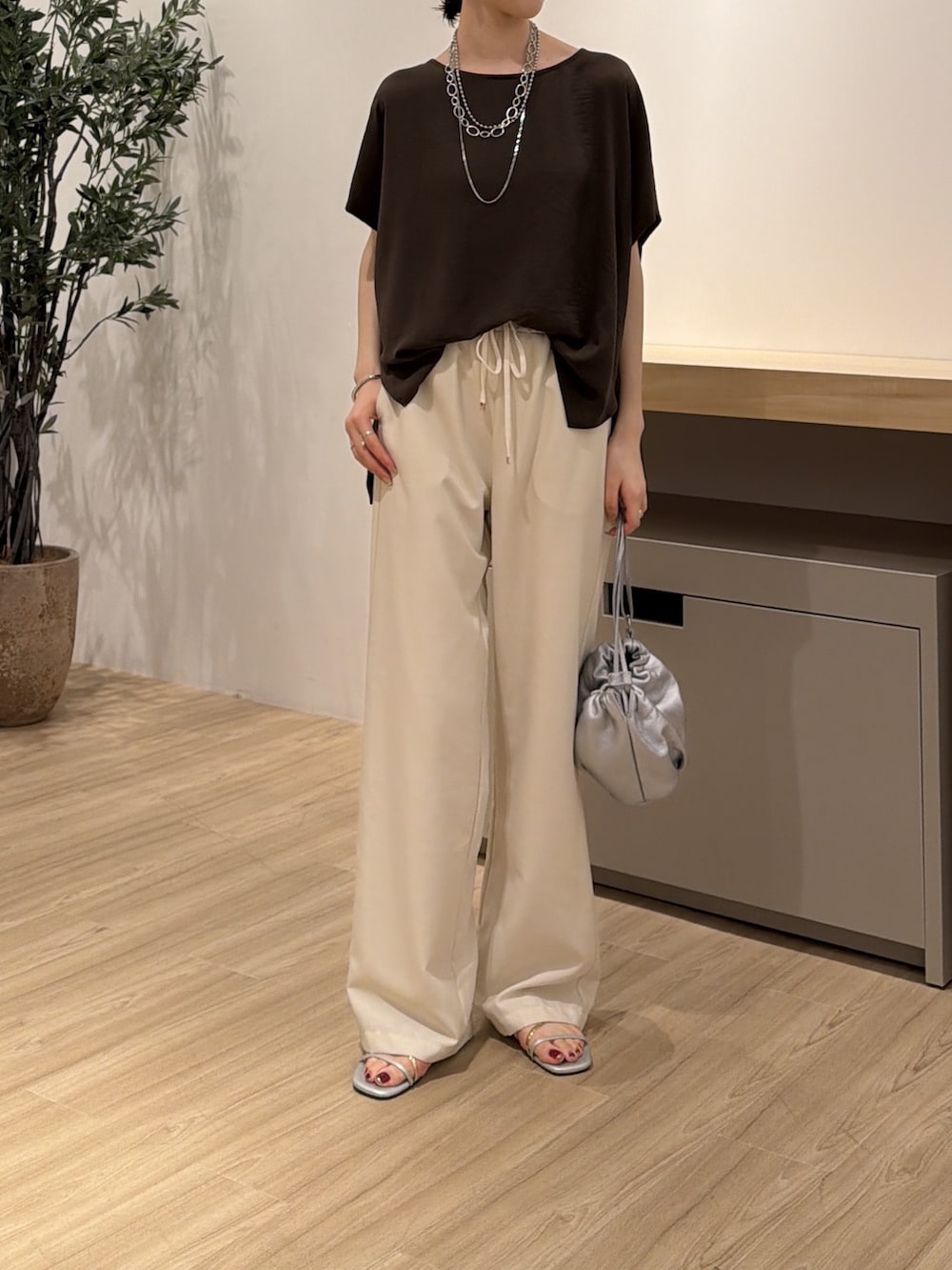 ホワイト系のその他パンツ、ブラウン系のシャツ/ブラウス、シルバー系のトートバッグを着用したレディースの夏コーディネートの2枚目の写真