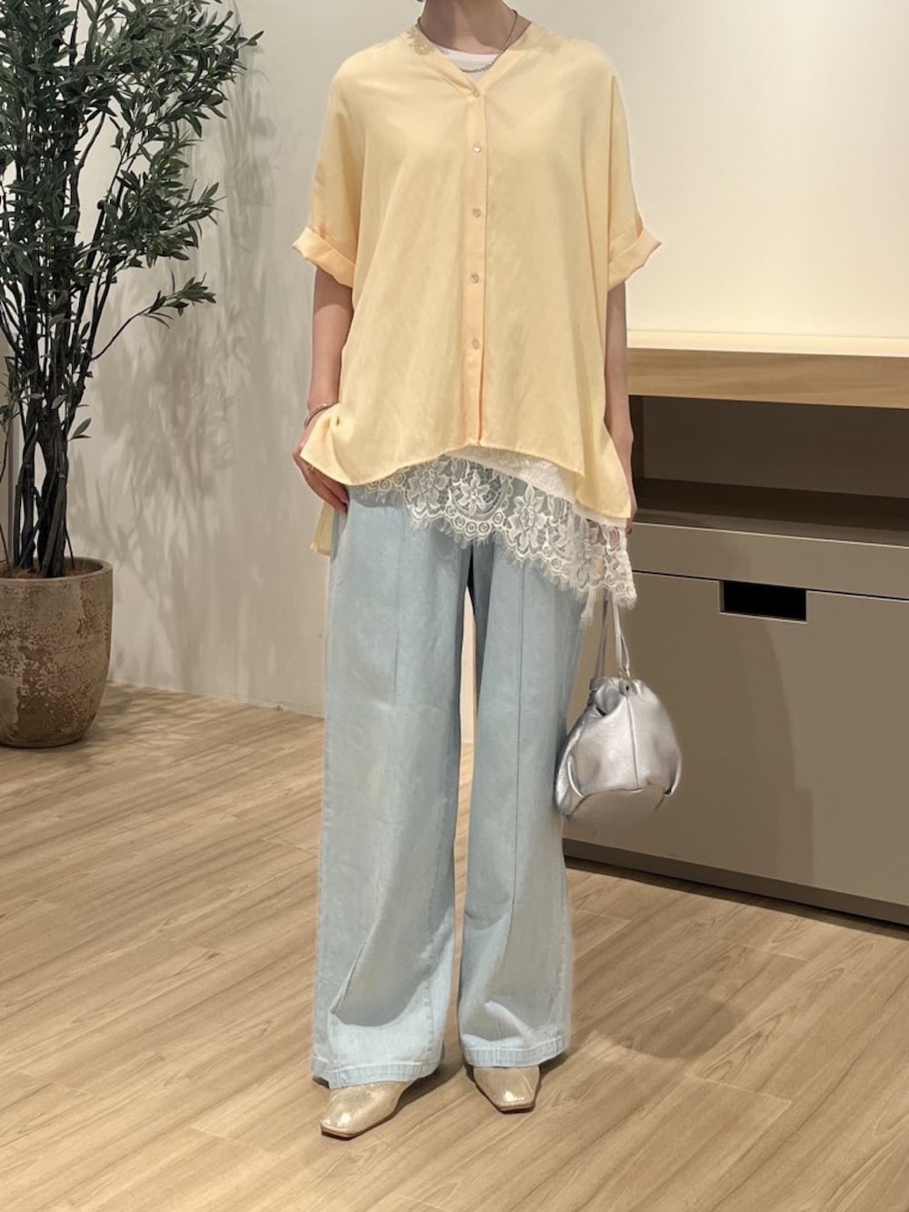 イエロー系のシャツ/ブラウス、ホワイト系のTシャツ/カットソー、ブルー系のデニムパンツを着用したレディースの夏コーディネートの2枚目の写真