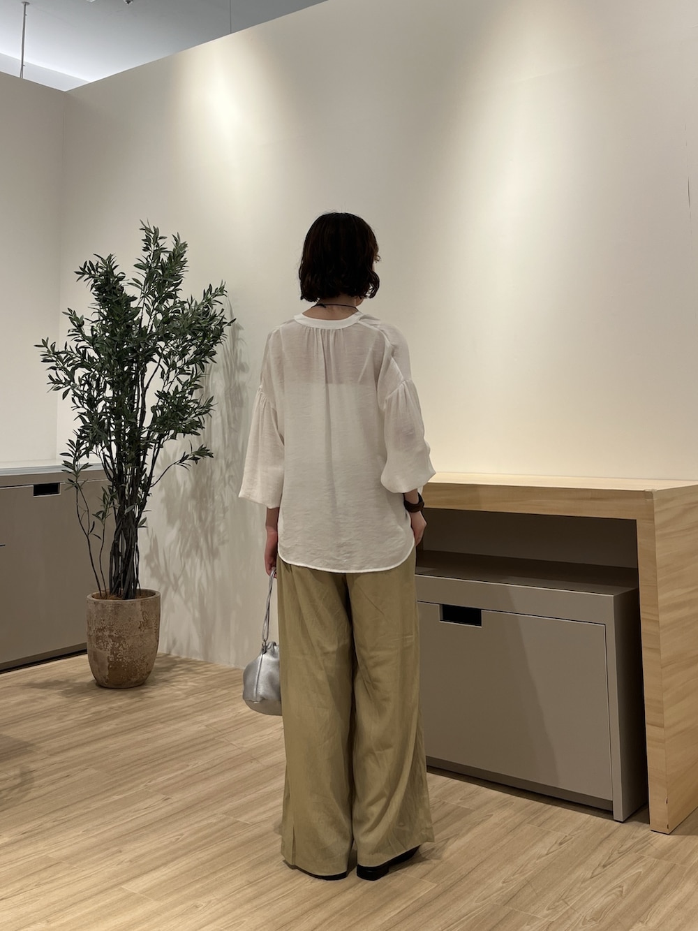 グリーン系のその他パンツ、シルバー系のトートバッグ、ホワイト系のシャツ/ブラウスを着用したレディースの夏コーディネートの3枚目の写真