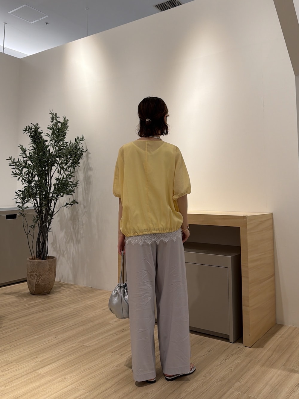 イエロー系のシャツ/ブラウス、シルバー系のサンダル、グレー系のその他パンツを着用したレディースの夏コーディネートの3枚目の写真