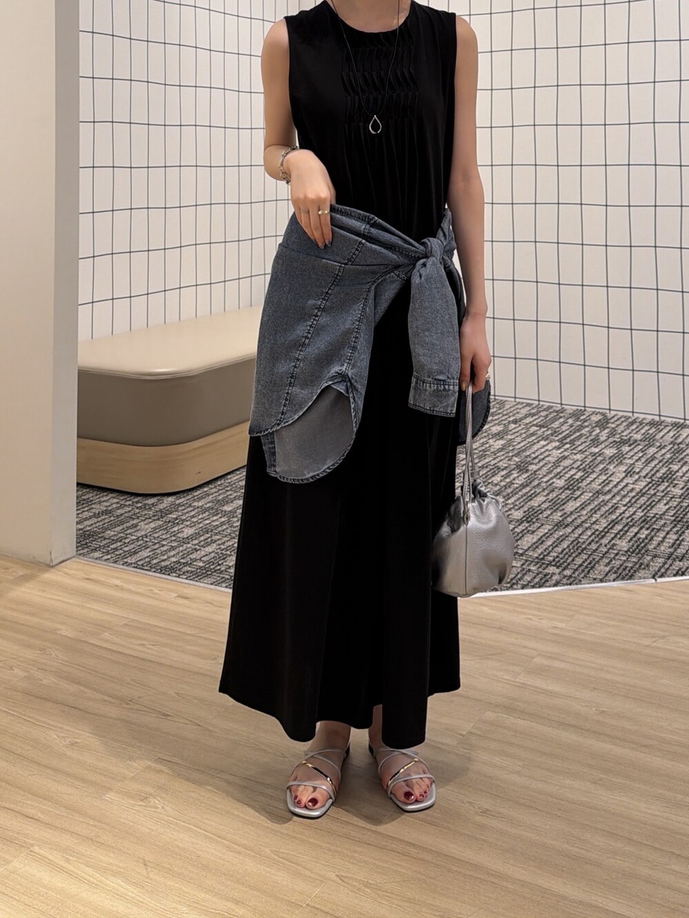 ブルー系のシャツ/ブラウス、シルバー系のトートバッグ、ブラック系のワンピースを着用したレディースの夏コーディネートの2枚目の写真