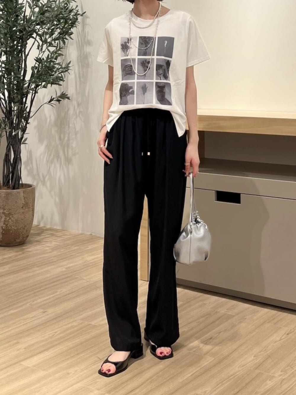 ホワイト系のTシャツ/カットソー、ブラック系のその他パンツ、シルバー系のトートバッグを着用したレディースの夏コーディネートの2枚目の写真