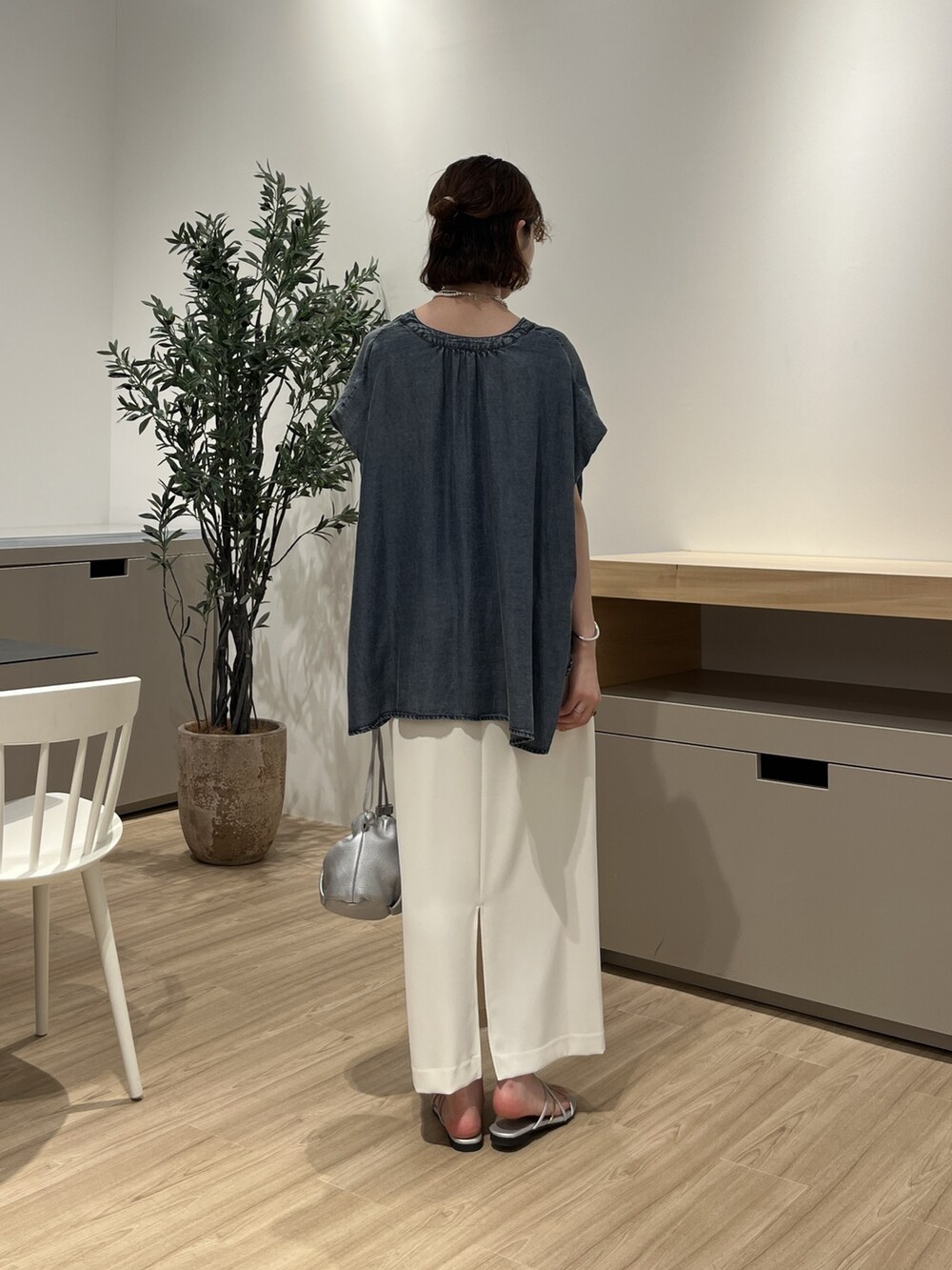 ブルー系のシャツ/ブラウス、ホワイト系のスカート、シルバー系のトートバッグを着用したレディースの夏コーディネートの2枚目の写真