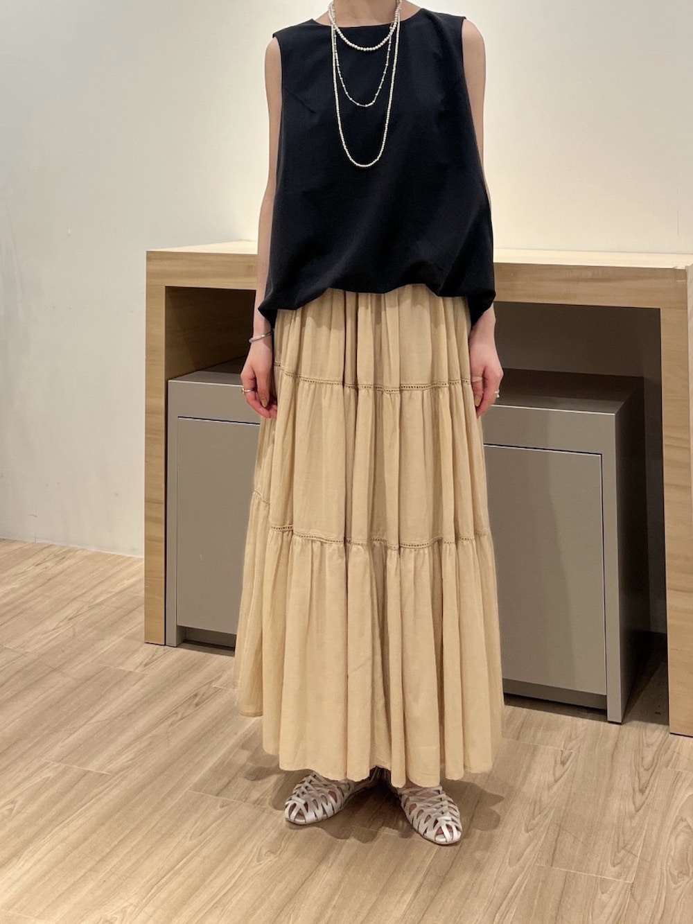 グレー系のワンピース、ベージュ系のスカート、ベージュ系のサンダルを着用したレディースの夏コーディネートの2枚目の写真