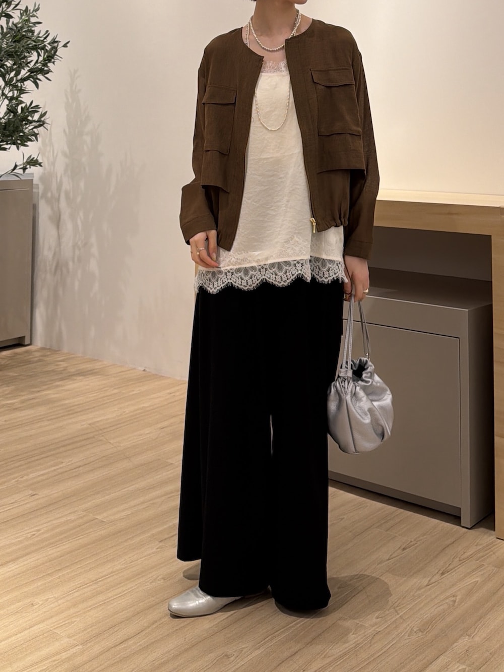 ブラウン系のベスト、ホワイト系のシャツ/ブラウス、ブラック系のその他パンツを着用したレディースの夏コーディネートの2枚目の写真