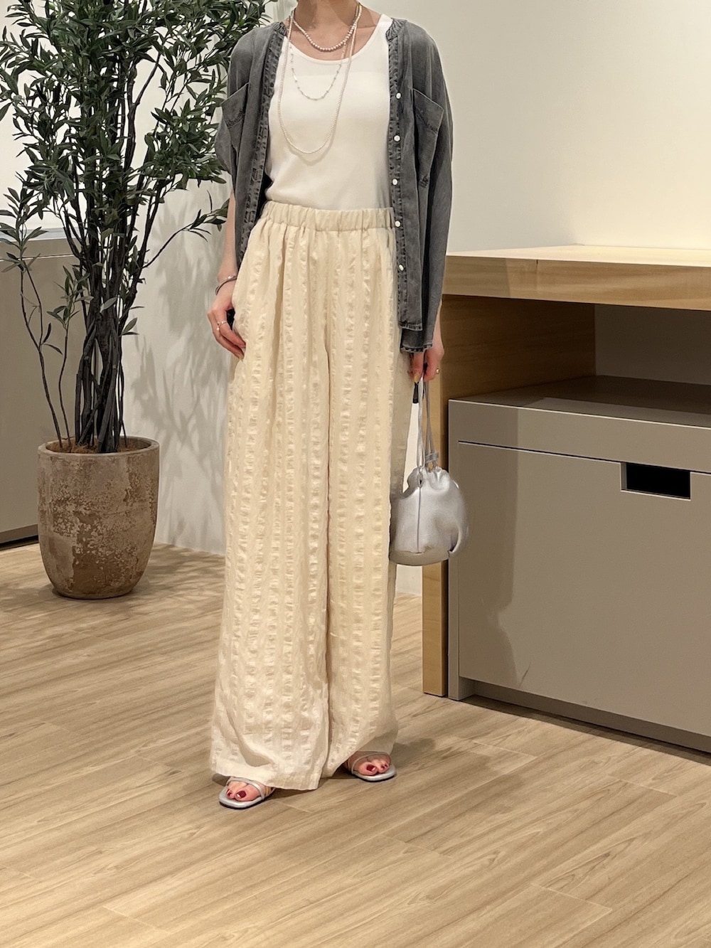 ホワイト系のキャミソール、ホワイト系のその他パンツ、シルバー系のトートバッグを着用したレディースの夏コーディネートの2枚目の写真