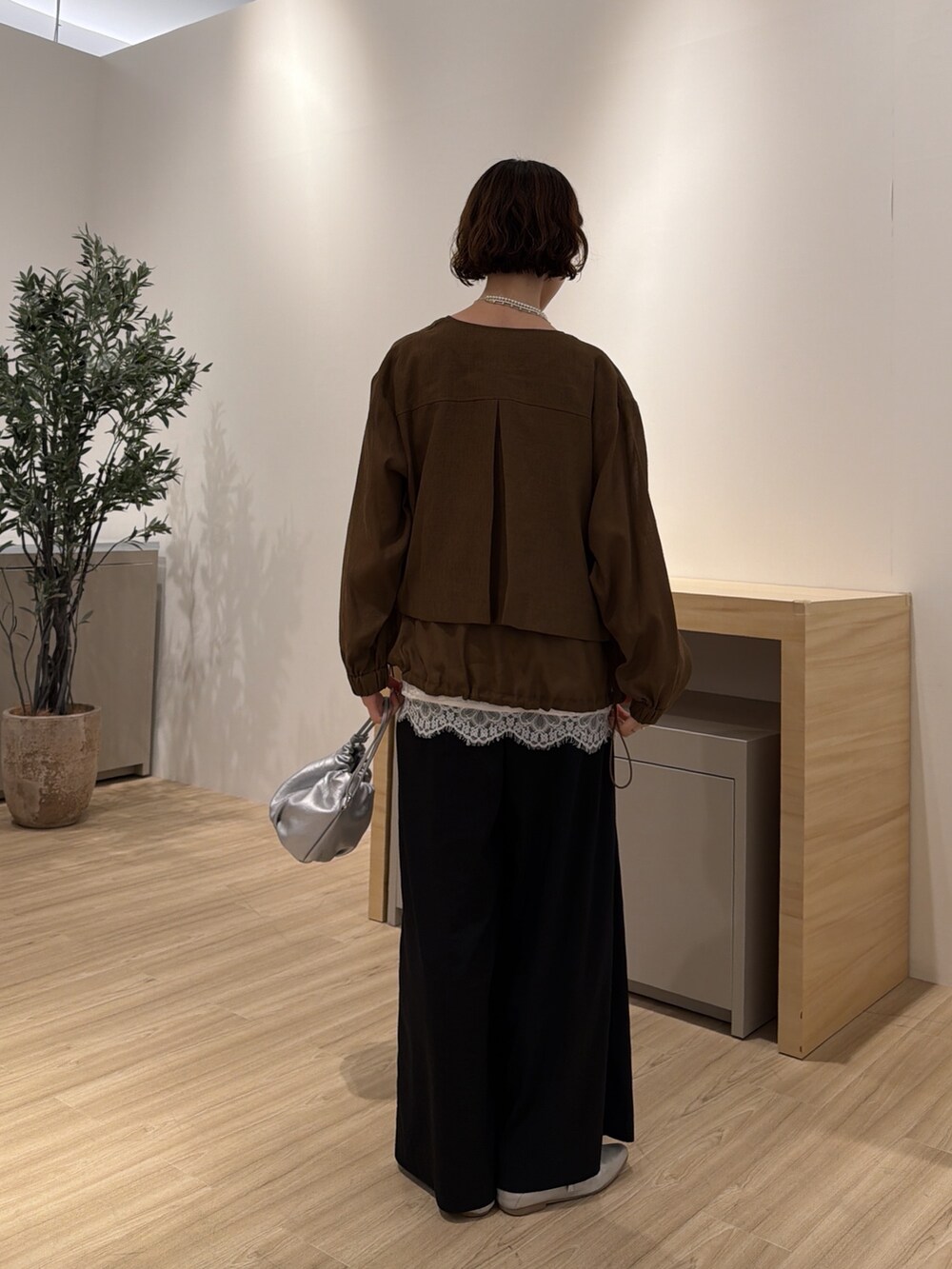 ブラウン系のベスト、ホワイト系のシャツ/ブラウス、ブラック系のその他パンツを着用したレディースの夏コーディネートの3枚目の写真