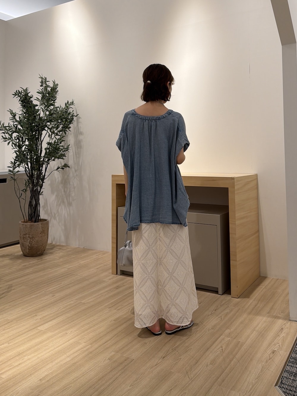 ホワイト系のワンピース、ブルー系のシャツ/ブラウス、シルバー系のトートバッグを着用したレディースの夏コーディネートの2枚目の写真