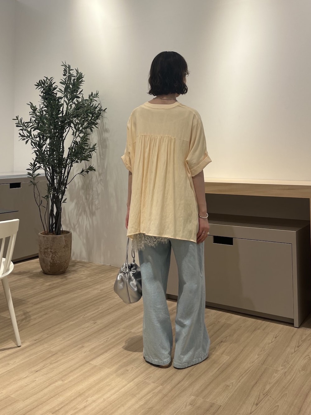 イエロー系のシャツ/ブラウス、ホワイト系のTシャツ/カットソー、ブルー系のデニムパンツを着用したレディースの夏コーディネートの3枚目の写真