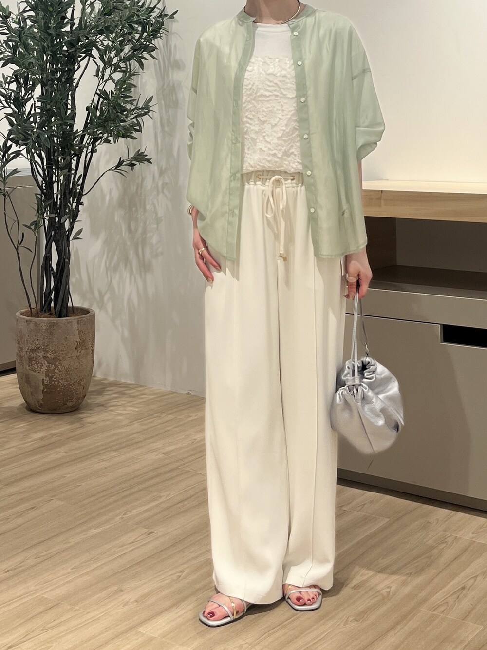 グリーン系のシャツ/ブラウス、ホワイト系のTシャツ/カットソー、シルバー系のトートバッグを着用したレディースの夏コーディネートの2枚目の写真