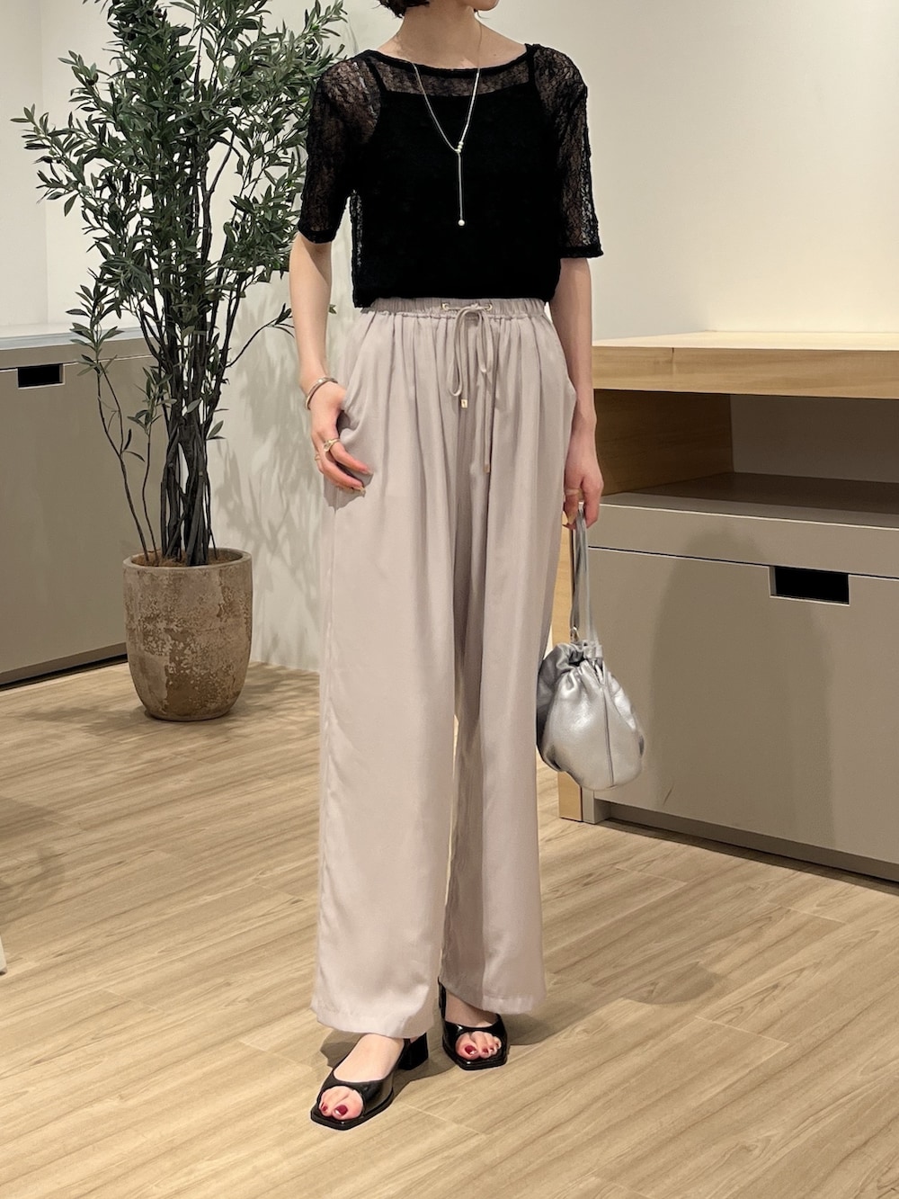 グレー系のその他パンツ、ブラック系のTシャツ/カットソー、シルバー系のトートバッグを着用したレディースの夏コーディネートの2枚目の写真