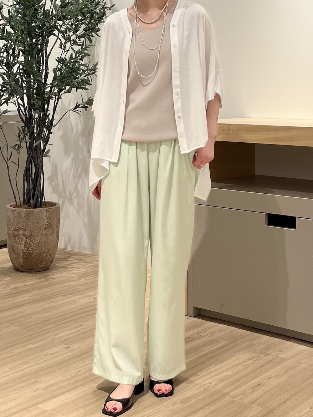 ホワイト系のシャツ/ブラウス、グレー系のニット/セーター、グリーン系のその他パンツを着用したレディースの夏コーディネートの2枚目の写真