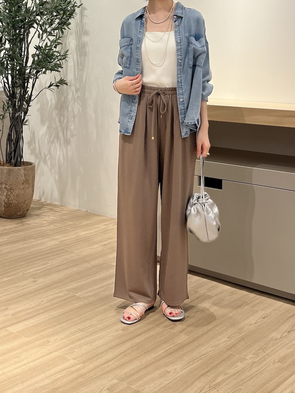 グレー系のその他パンツ、ブルー系のシャツ/ブラウス、シルバー系のサンダルを着用したレディースの夏コーディネートの2枚目の写真