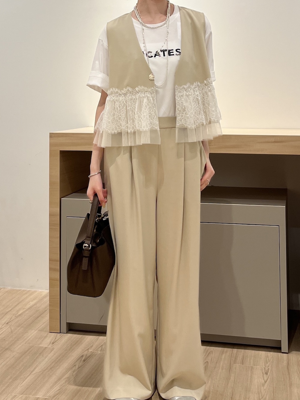 ベージュ系のワンピース、ホワイト系のTシャツ/カットソーを着用したレディースの夏コーディネートの2枚目の写真