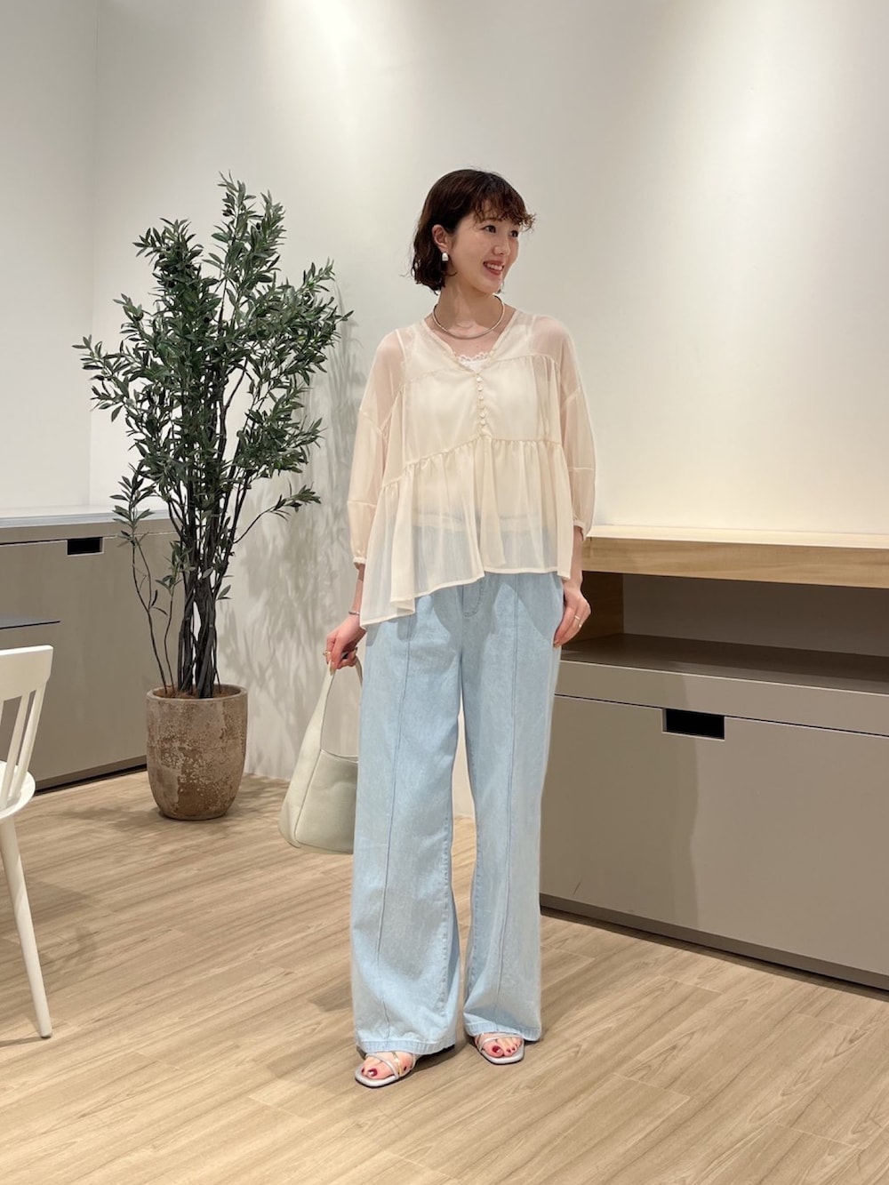 ホワイト系のシャツ/ブラウス、ブルー系のデニムパンツ、シルバー系のサンダルを着用したレディースの夏コーディネートの3枚目の写真