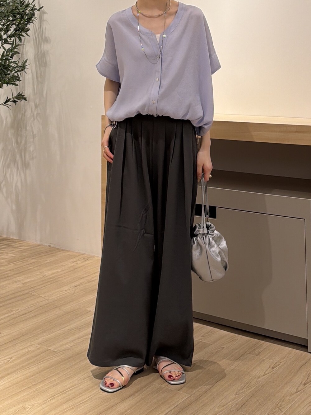 パープル系のシャツ/ブラウス、グレー系のその他パンツ、シルバー系のトートバッグを着用したレディースの夏コーディネートの2枚目の写真
