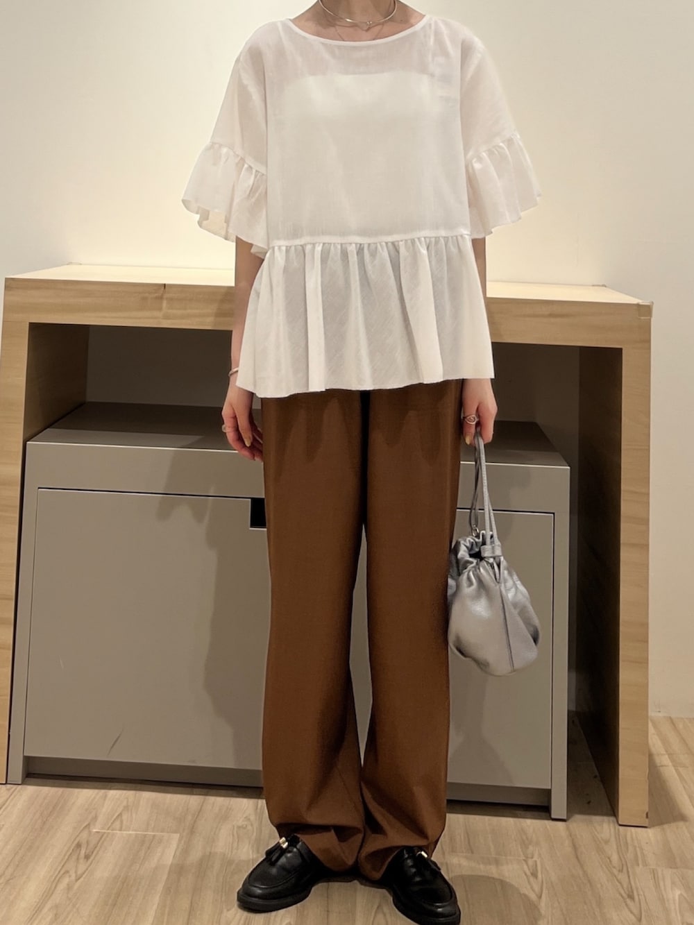 ホワイト系のシャツ/ブラウス、ブラウン系のその他パンツ、シルバー系のトートバッグを着用したレディースの夏コーディネートの2枚目の写真