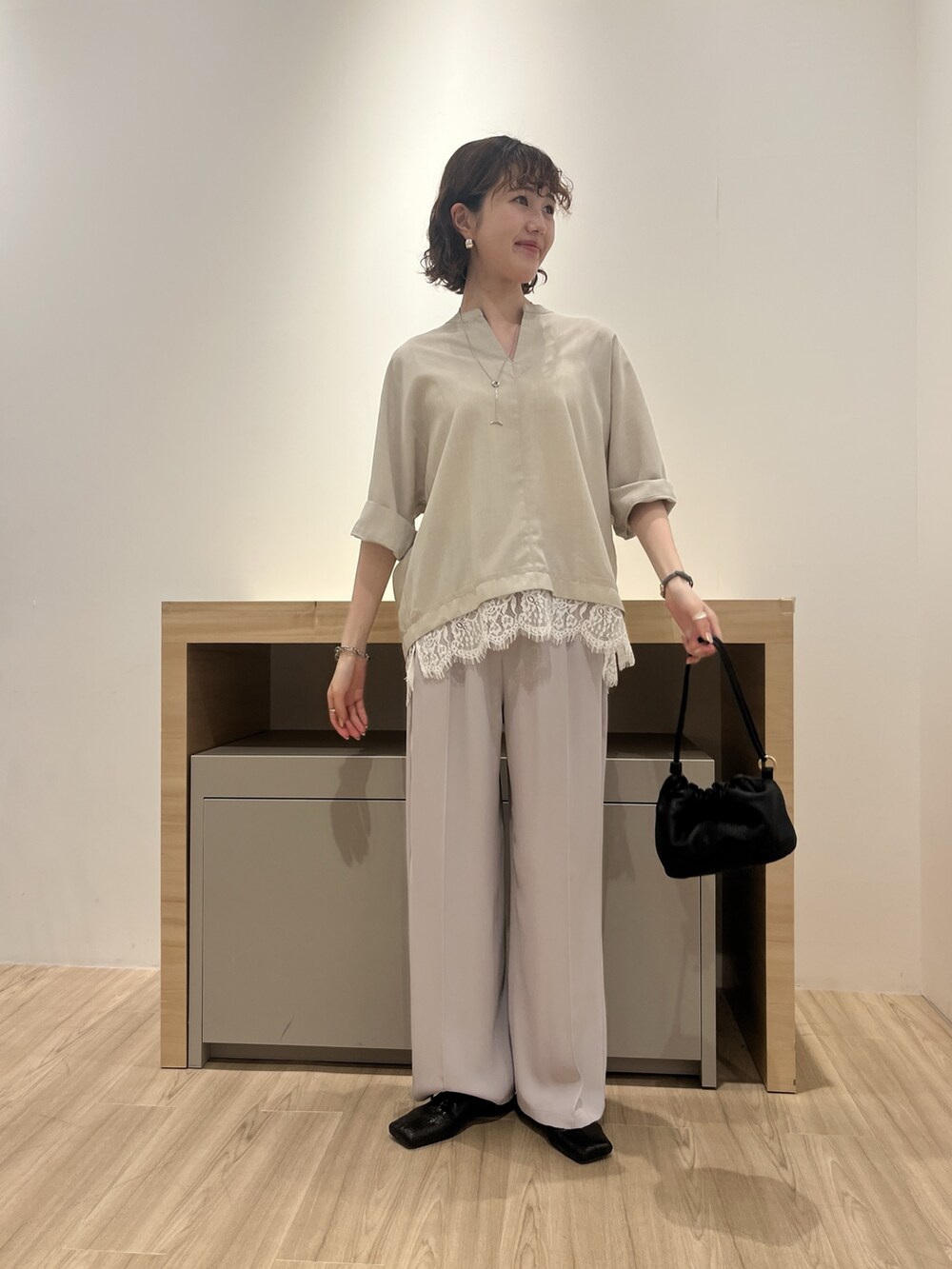 ベージュ系のシャツ/ブラウス、グレー系のその他パンツ、ブラック系のトートバッグを着用したレディースの夏コーディネートの2枚目の写真