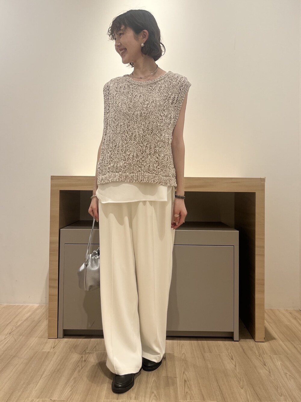 ホワイト系のニット/セーター、ホワイト系のTシャツ/カットソー、シルバー系のトートバッグを着用したレディースの夏コーディネートの2枚目の写真