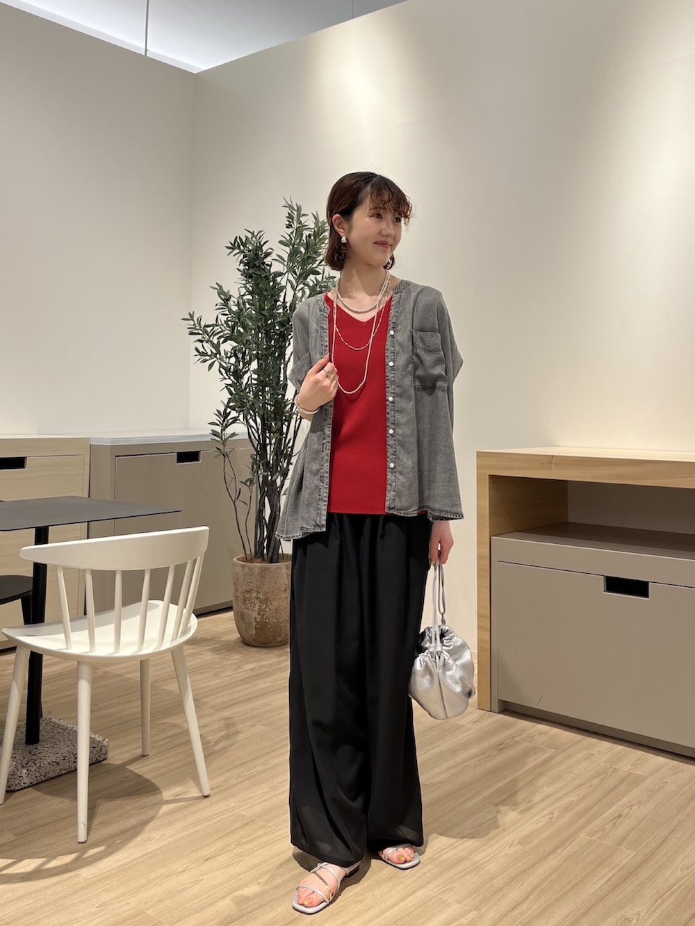 グレー系のシャツ/ブラウス、レッド系のニット/セーター、ブラック系のその他パンツを着用したレディースの夏コーディネートの2枚目の写真