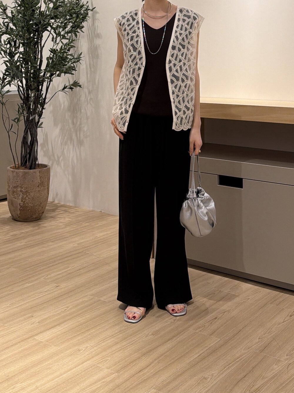 グレー系のニット/セーター、ホワイト系のワンピース、ブラック系のその他パンツを着用したレディースの夏コーディネートの2枚目の写真