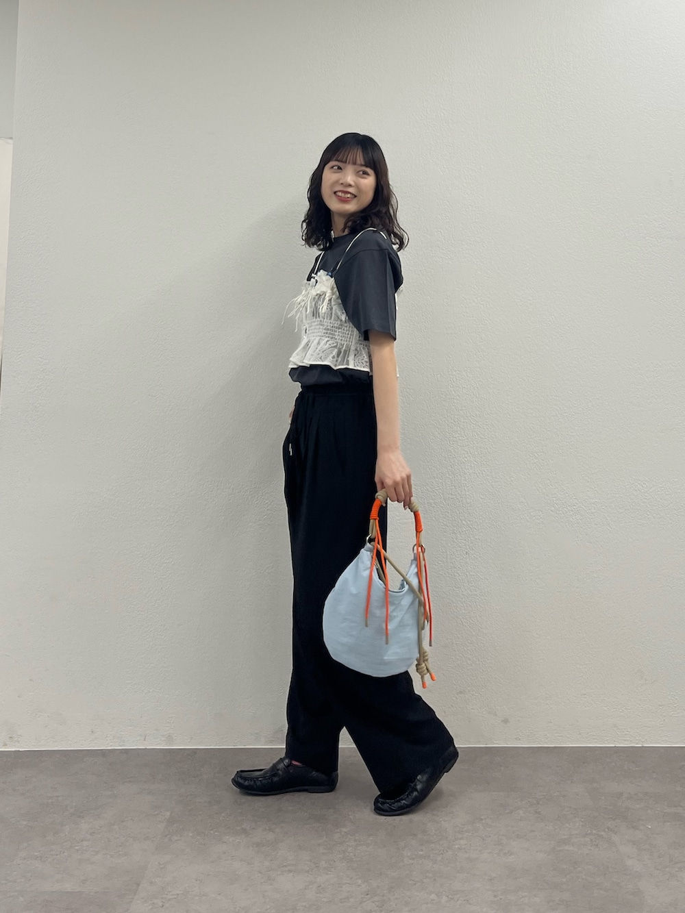 ブルー系のショルダーバッグ、ホワイト系のキャミソール、グレー系のTシャツ/カットソーを着用したレディースの春コーディネートの2枚目の写真