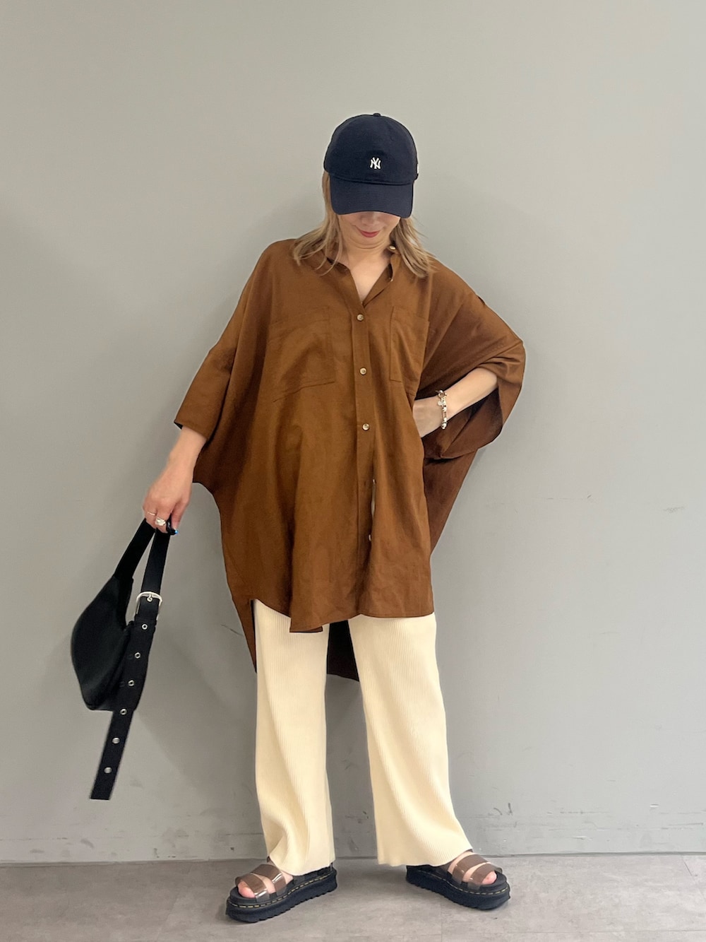 ブラック系のショルダーバッグ、ブラウン系のシャツ/ブラウス、ホワイト系のその他パンツを着用したレディースの夏コーディネートの2枚目の写真