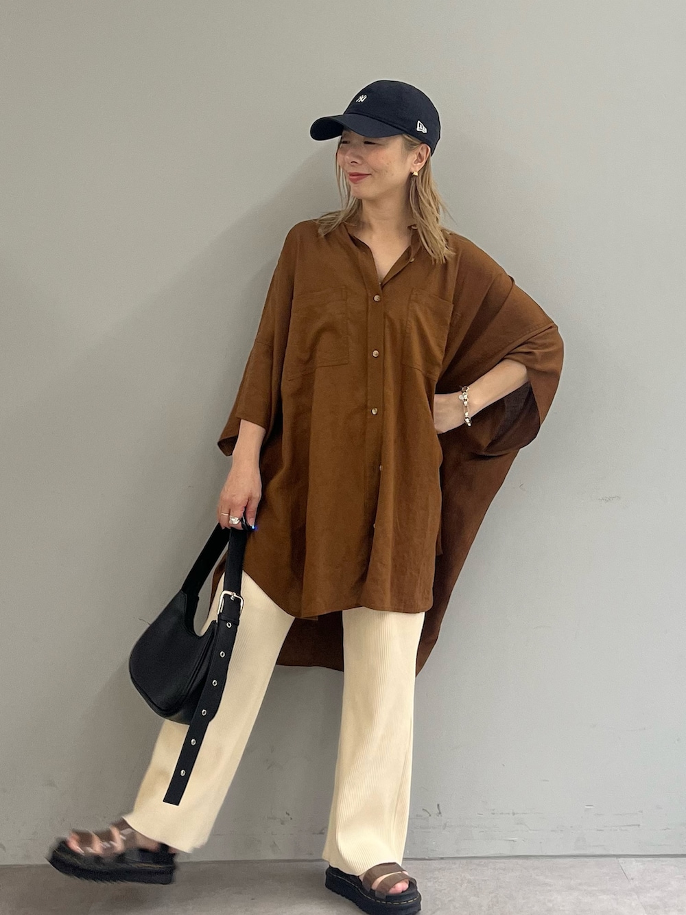 ブラック系のショルダーバッグ、ブラウン系のシャツ/ブラウス、ホワイト系のその他パンツを着用したレディースの夏コーディネートの3枚目の写真