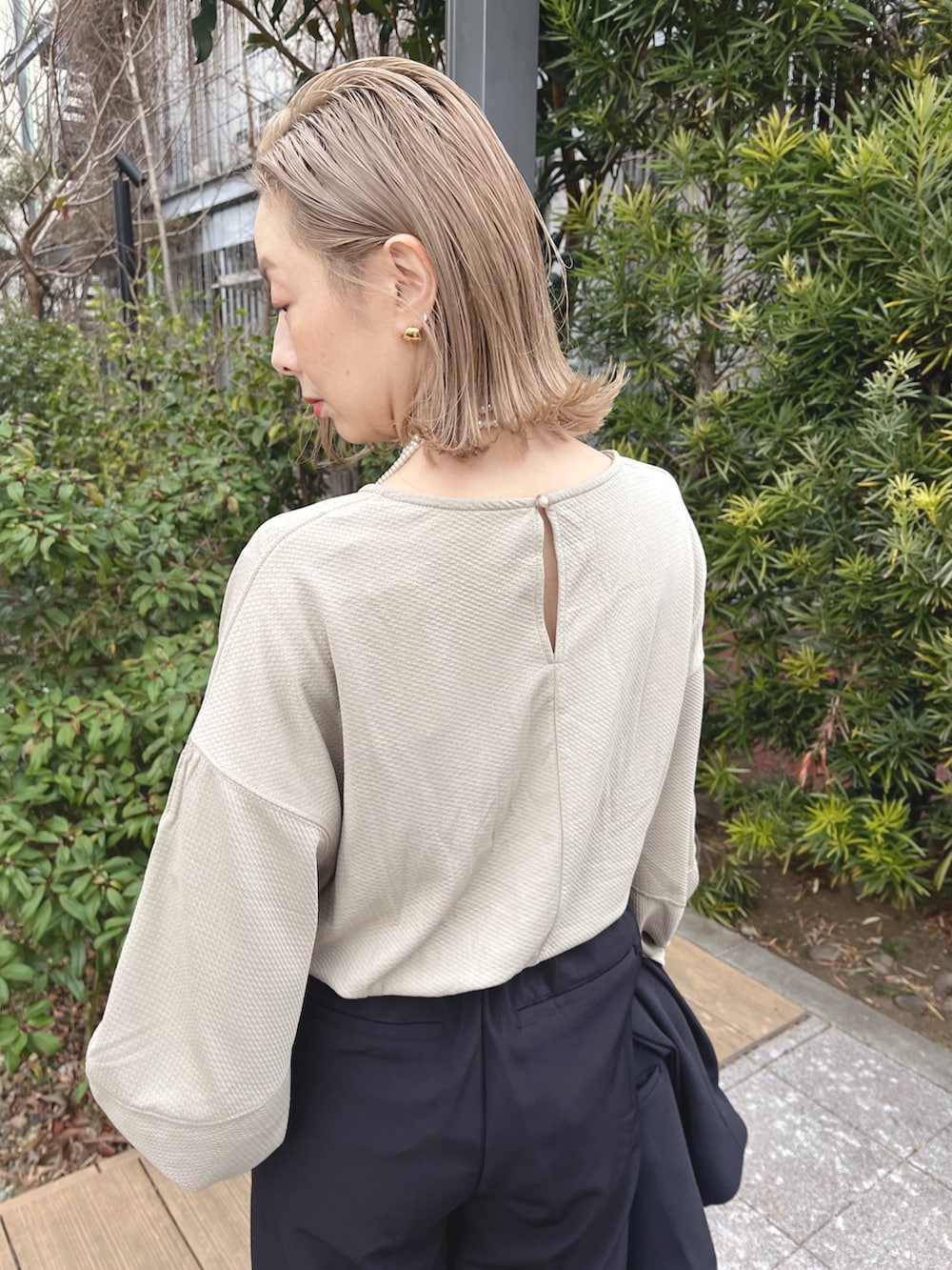 ブラック系のスラックス、ベージュ系のTシャツ/カットソー、ブラック系のテーラードジャケットを着用したレディースの冬コーディネートの3枚目の写真