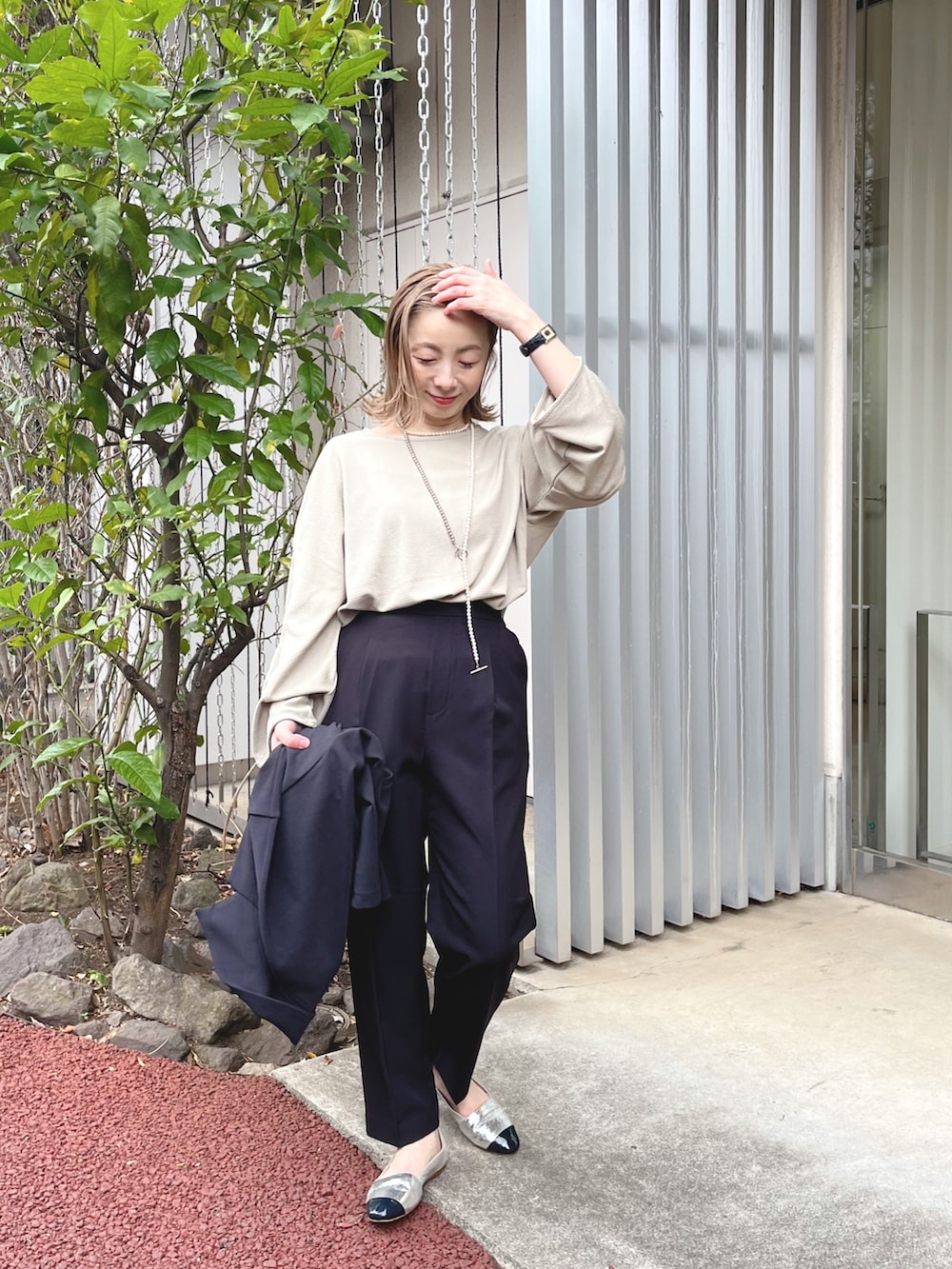 ブラック系のスラックス、ベージュ系のTシャツ/カットソー、ブラック系のテーラードジャケットを着用したレディースの冬コーディネートの2枚目の写真