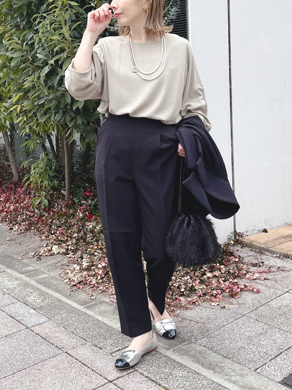 ブラック系のスラックス、ベージュ系のTシャツ/カットソー、ブラック系のテーラードジャケットを着用したレディースの冬コーディネートの5枚目の写真