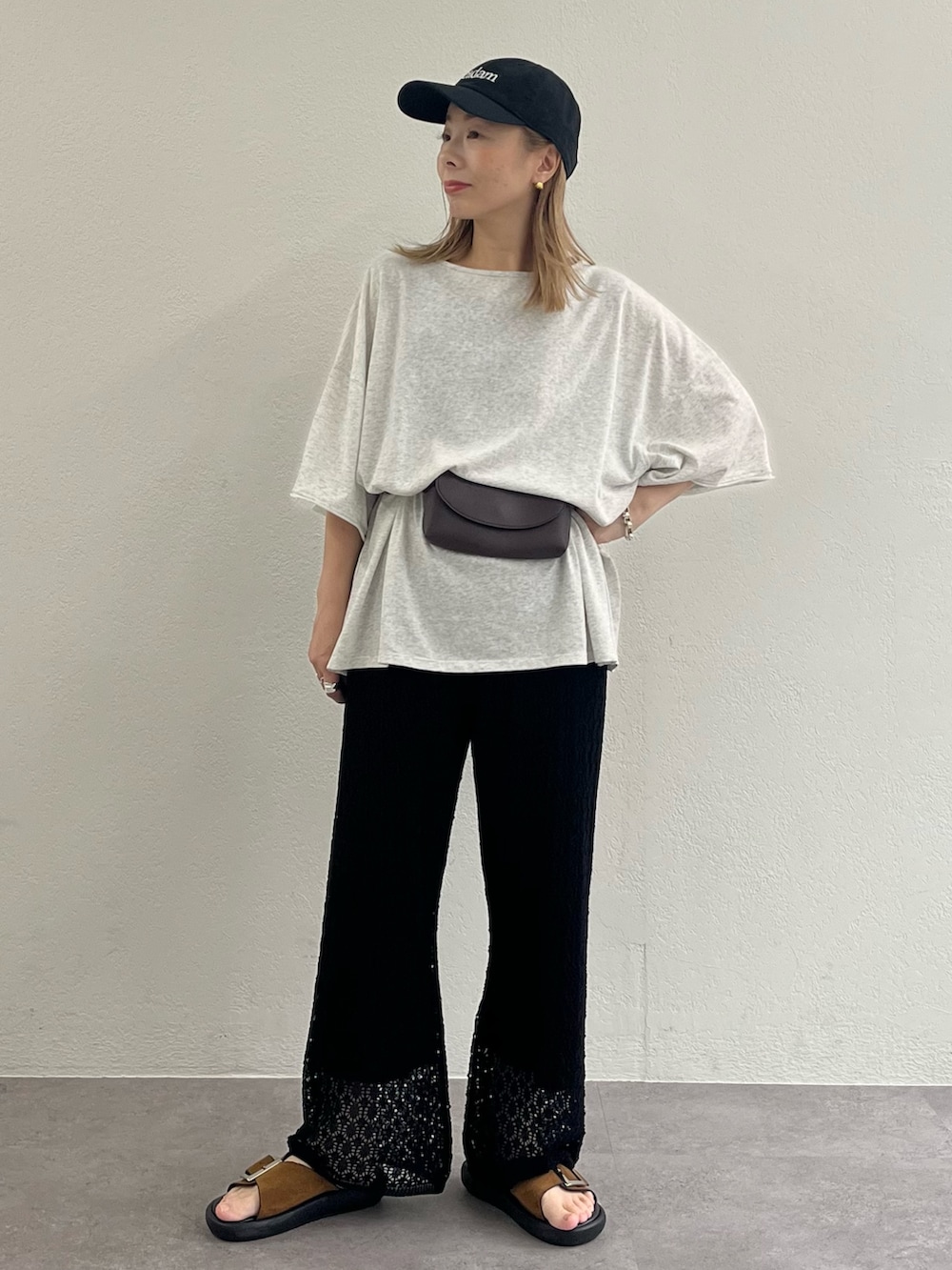 ブラウン系のサンダル、ブラック系のその他パンツ、グレー系のTシャツ/カットソーを着用したレディースの夏コーディネートの2枚目の写真