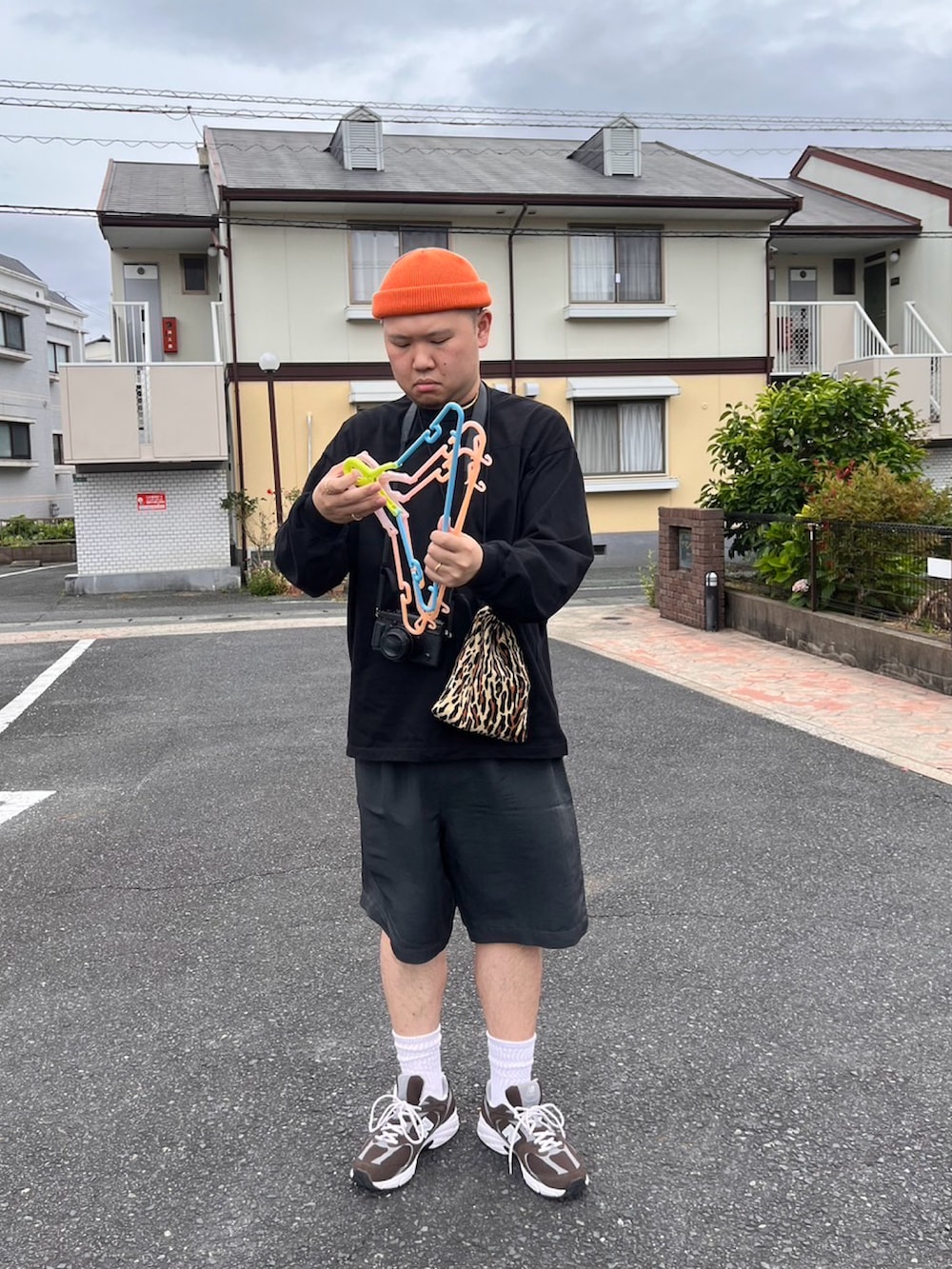 ブラック系のパンツ、ブラック系のTシャツ/カットソー、ブラウン系のスニーカーを着用したメンズの夏コーディネートの2枚目の写真