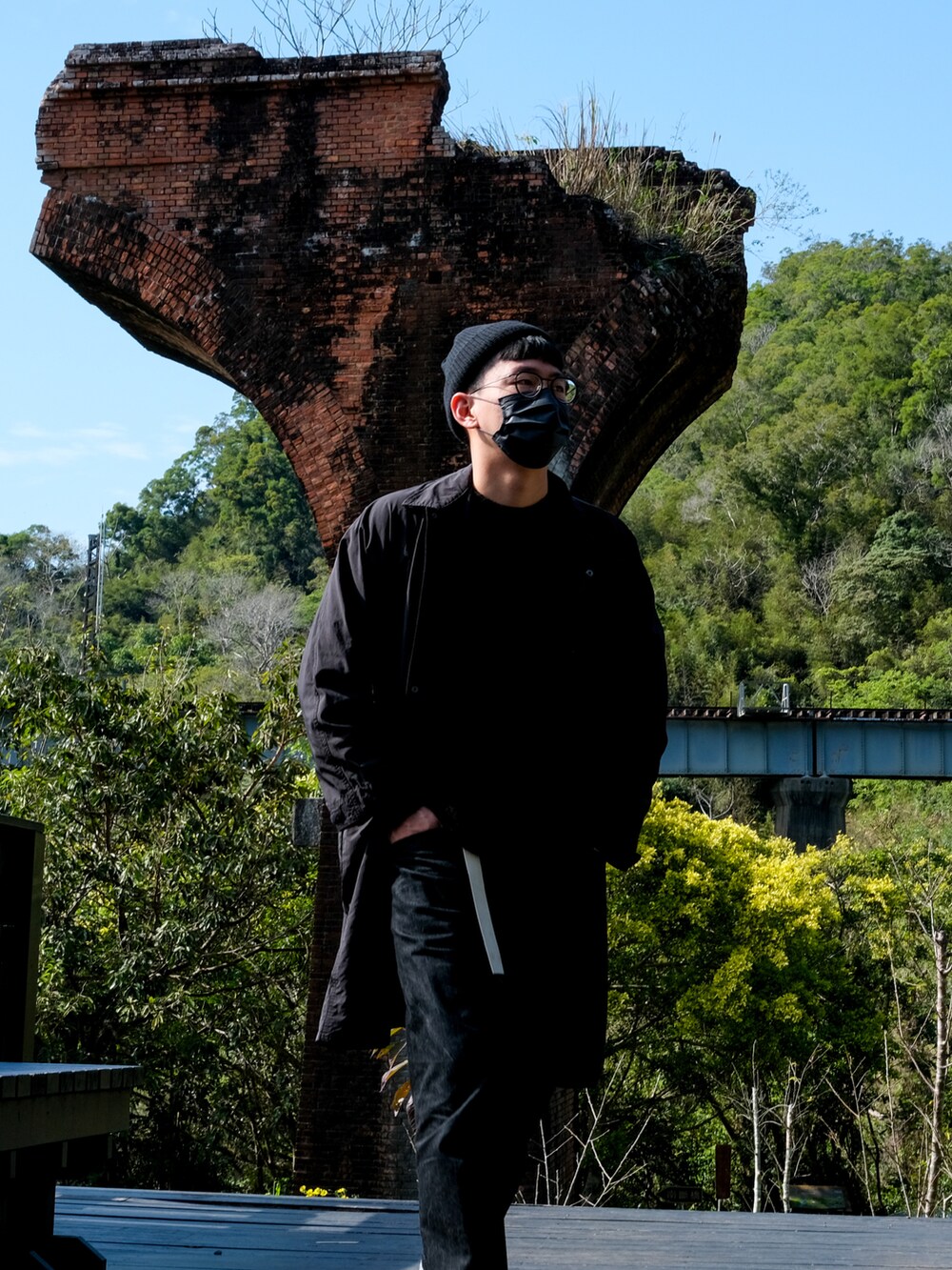 ブラック系のデニムパンツ、ブラック系のサンダル、ブラウン系のトップスを着用したメンズの冬コーディネートの4枚目の写真