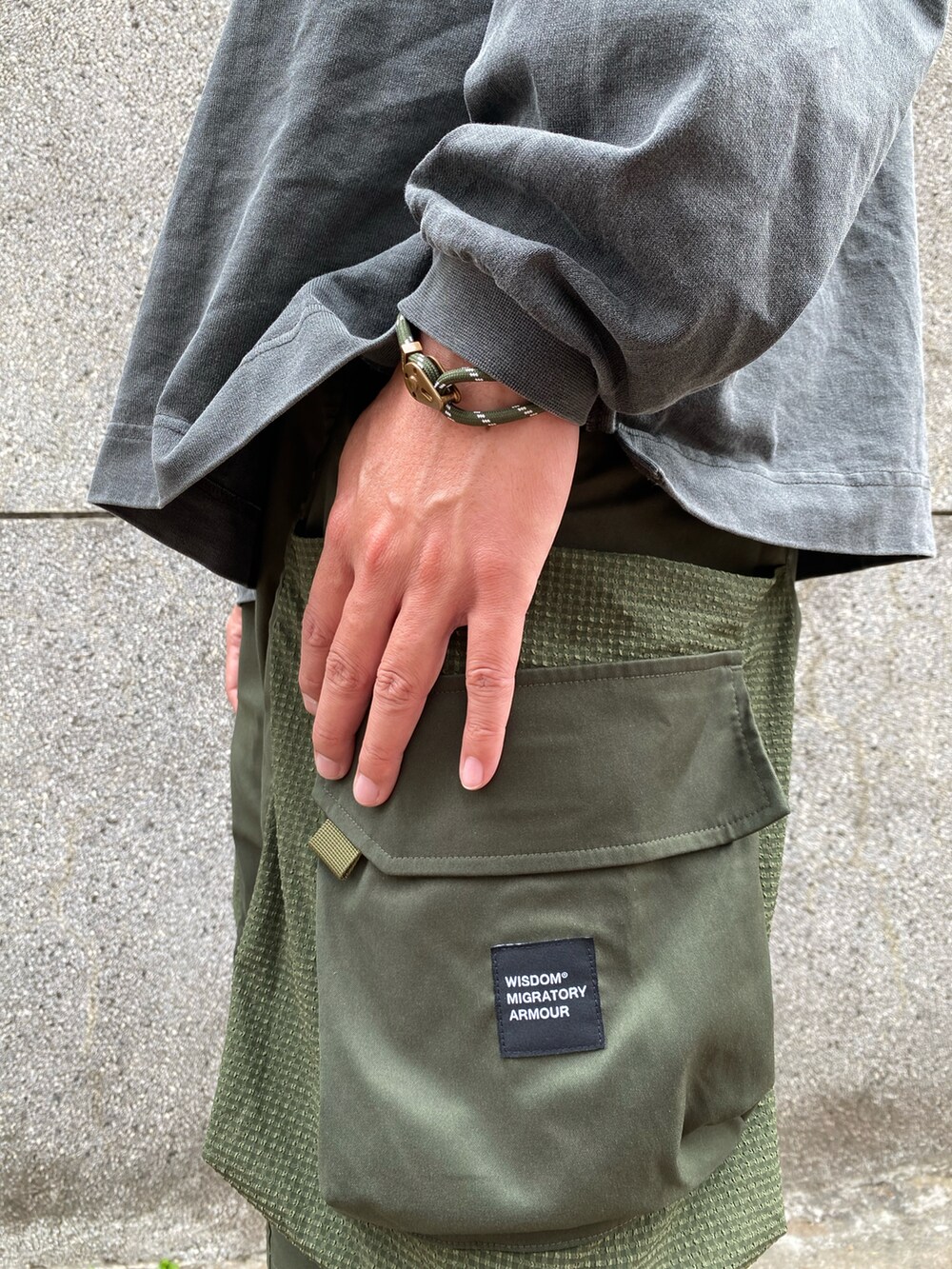 グレー系のTシャツ/カットソー、グリーン系のパンツ、グレー系のシューズを着用したメンズの冬コーディネートの3枚目の写真