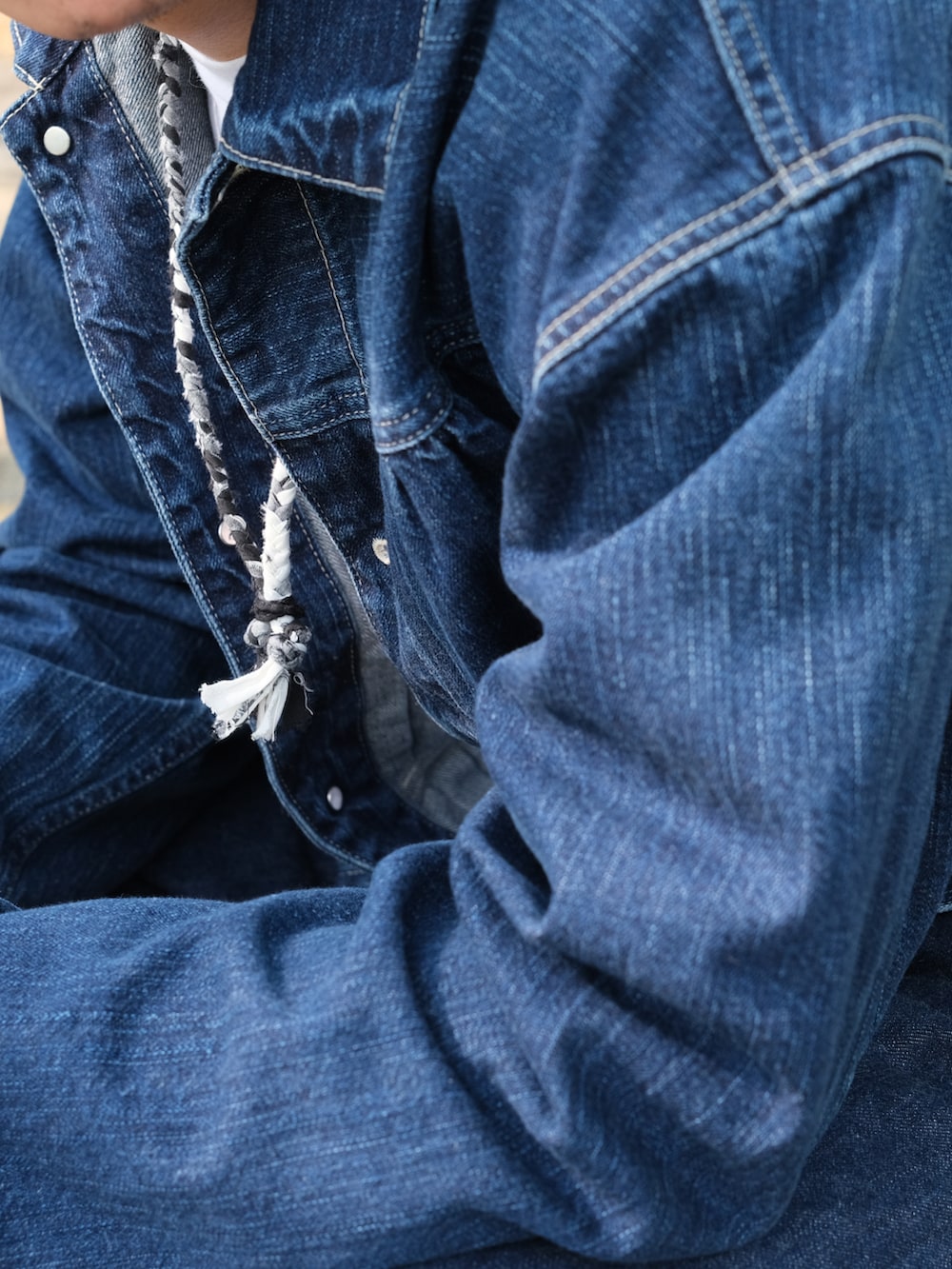 ブルー系のジャケット/アウター、ブルー系のデニムパンツ、グレー系のネックレスを着用したメンズの春コーディネートの5枚目の写真