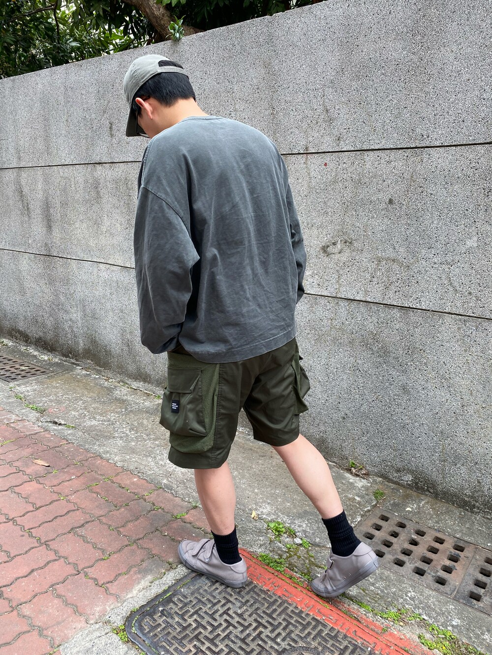 グレー系のTシャツ/カットソー、グリーン系のパンツ、グレー系のシューズを着用したメンズの冬コーディネートの2枚目の写真