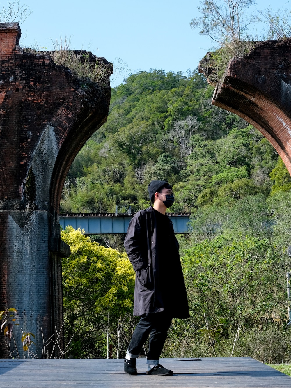 ブラック系のデニムパンツ、ブラック系のサンダル、ブラウン系のトップスを着用したメンズの冬コーディネートの2枚目の写真