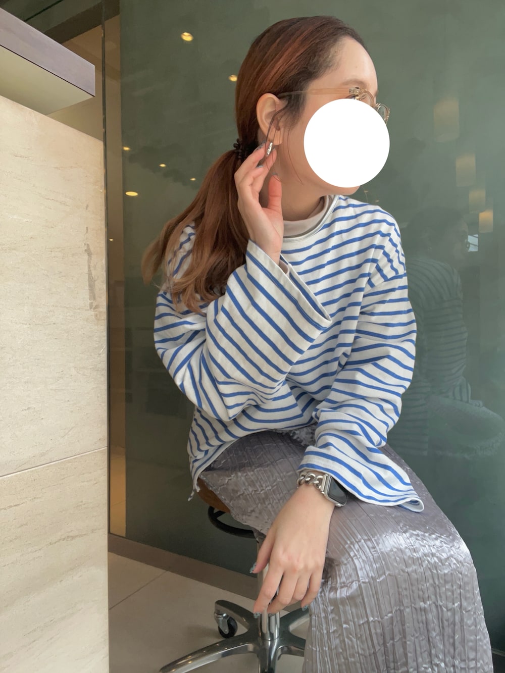 シルバー系のスカート、ブルー系のTシャツ/カットソー、ブラック系のスニーカーを着用したレディースの冬コーディネートの3枚目の写真